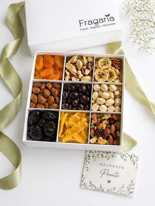 Caja blanca de nueve secciones con frutos secos y frutas deshidratadas.
