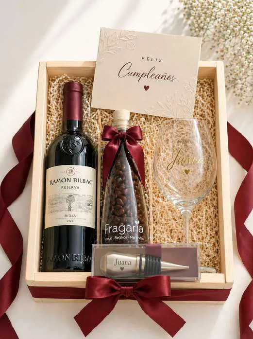 Caja de madera con vino tinto, copa grabada con nombre, botella de chocouvas y tapón de acero, con cintas color vino.